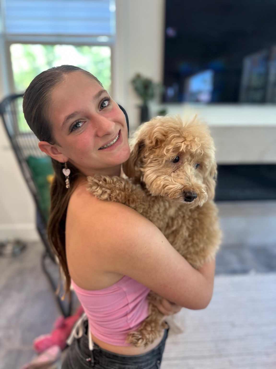 Teen girl hugging a fluffy tan dog